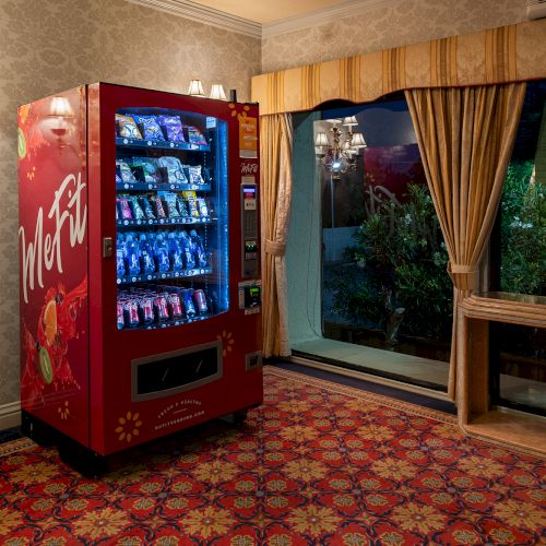 A building interior with a large aquarium display and several plants by a window, making a cozy, tropical vibe.